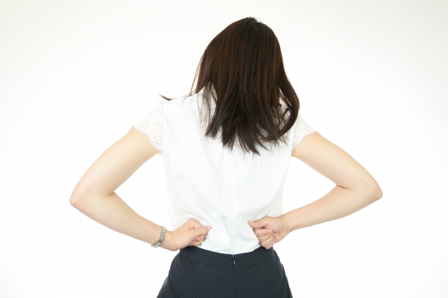 腰に手を当てる女性の後ろ姿