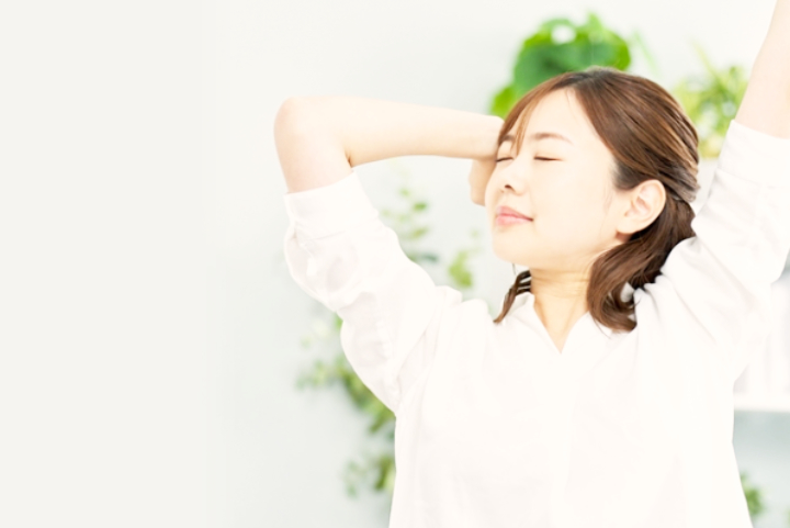 腕を上げて目を閉じる女性