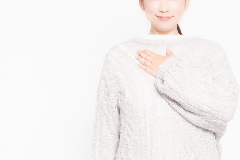 胸に手を当てている女性